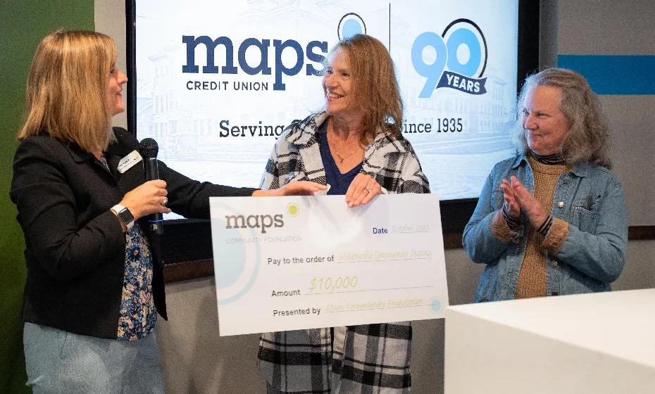 2 mujeres de Wilsonville Sharing están recibiendo un cheque promocional