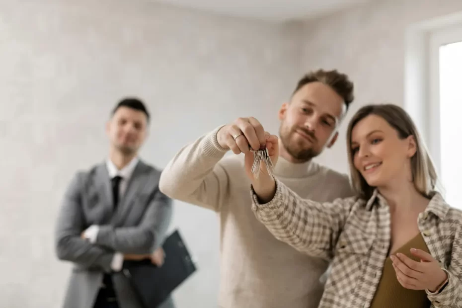 Couple looking at new home with realtor in the background
